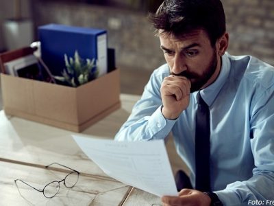 Worried businessman going through paperwork after losing his job in the office.