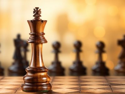 Chess piece in the foreground, with the board in the back.