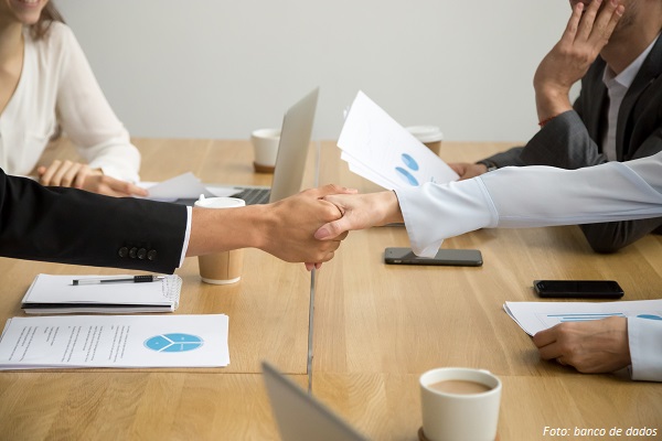 Diverse businessman and businesswoman handshaking at group meeting, close up view of white female and black male hands shaking as concept of gender equality racial diversity in business, making deal